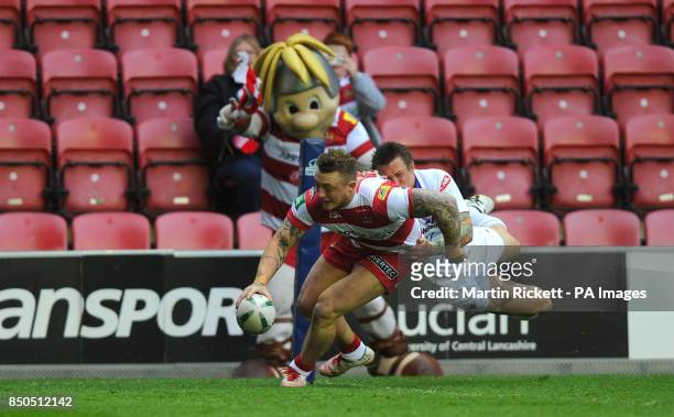 Wigan Warriors Josh Charnley breaks away from Salford City Reds' Ryan McGoldrick and goes over for a try during the Super League match at the DW...