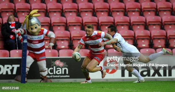 Wigan Warriors Josh Charnley breaks away from Salford City Reds' Ryan McGoldrick and goes over for a try during the Super League match at the DW...