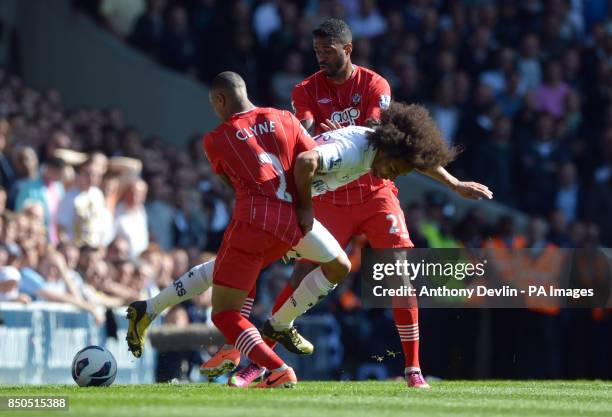 Tottenham's Benoit Assou-Ekotto is tackled by Southampton's Nathaniel Clyne and Guly Do Prado during the Barclays Premier League match at White Hart...