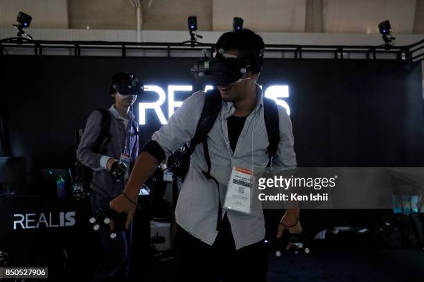 Visitors wearing a VR headset play a video game in the Shenzhen Realis Multimedia Technology Co.,Ltd. Booth during the Tokyo Game Show 2017 at...