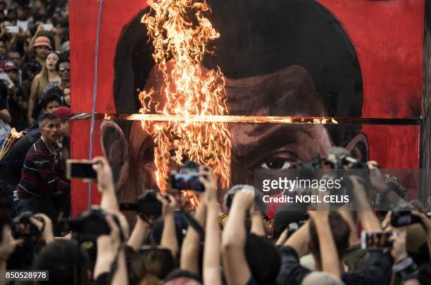 Activists burn an effigy during a protest against Philippine President Rodrigo Duterte near the Malacanang palace in Manila on September 21, 2017. -...