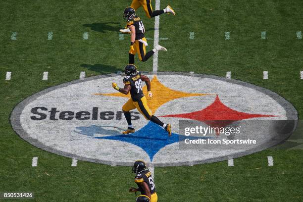 Inside linebacker Vince Williams of the Pittsburgh Steelers and teammates run over the Pittsburgh Steelers logo on the field during an NFL football...