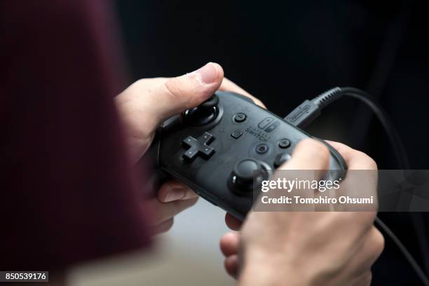 Visitor plays the Biohazard revelations 2 video game on Nintendo Co.'s Switch game console in the Capcom Co. Booth during the Tokyo Game Show 2017 at...