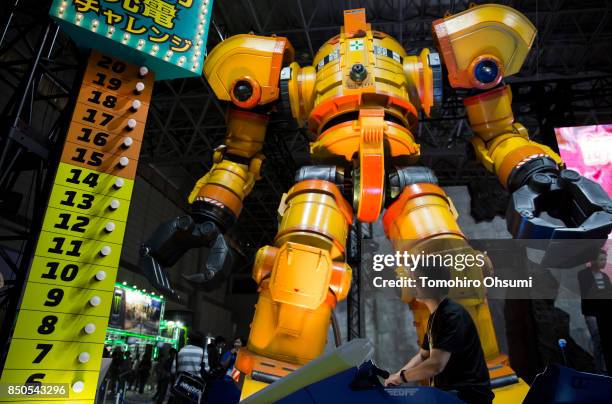 Visitor tries charging the battery of a robot in the Earth Defense Force video game booth during the Tokyo Game Show 2017 at Makuhari Messe on...
