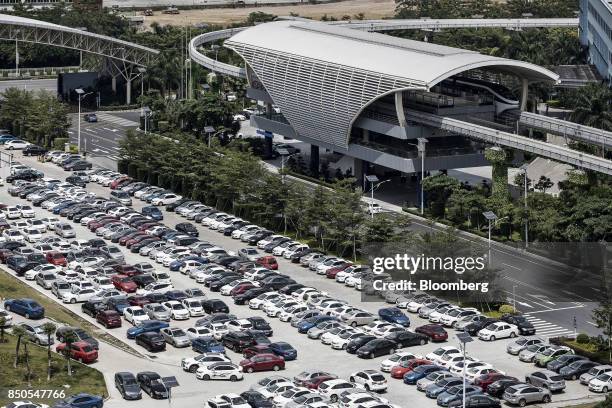 Co. SkyRail monorail train stands at a station as vehicles stand parked in a lot at the company's headquarters in Shenzhen, China, on Thursday, Sept....