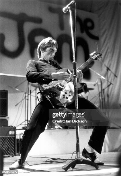 Photo of JAM and Paul WELLER; Paul Weller performing live onstage, playing Rickenbacker 330 guitar, with The Jam logo on backdrop behind