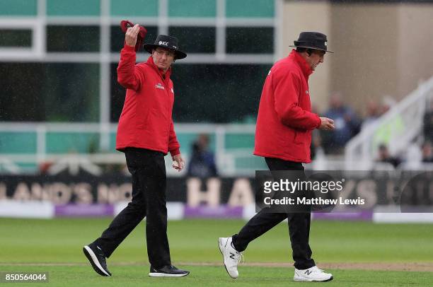 Umpire Rod Tucker calls the players in, after rain delays play during the 2nd Royal London One Day International between England and West Indies at...