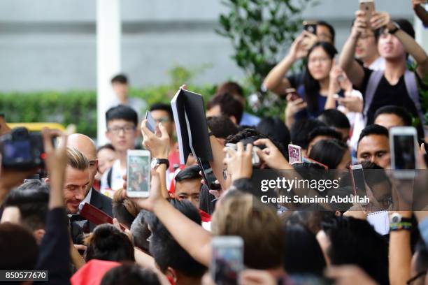 David Beckham signs autograph for fans during the AIA Vitality Healthy Cookout Showdown on September 21, 2017 in Singapore. David Beckham is in...