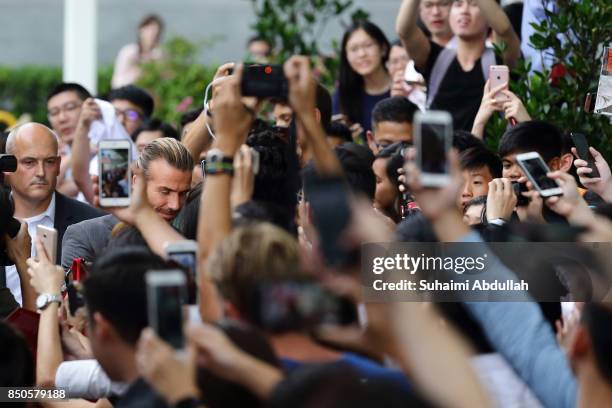 David Beckham signs autograph for fans during the AIA Vitality Healthy Cookout Showdown on September 21, 2017 in Singapore. David Beckham is in...