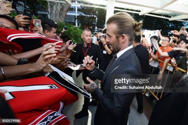 David Beckham signs autograph for fans after attending the AIA Vitality Healthy Cookout Showdown on September 21, 2017 in Singapore. David Beckham is...