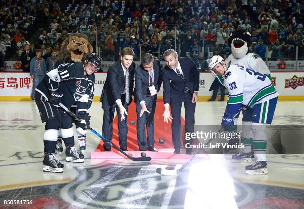 Anze Kopitar of the Los Angeles Kings and Henrik Sedin of the Vancouver Canucks take a ceremonial face-off from Luc Robitaille, Sun Weimin and Trevor...