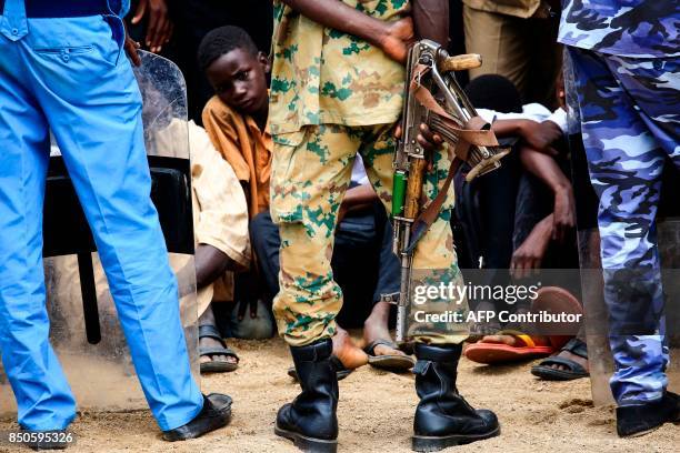 Sudanese soldier carries a Kalashnikov assault rifle while standing guard during a speech given by President Omar al-Bashir in Nyala, the capital of...