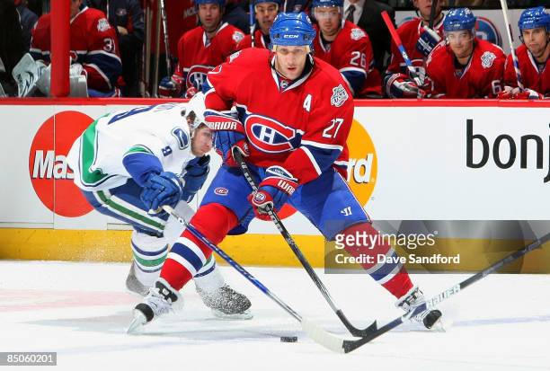 Alex Kovalev of the Montreal Canadiens carries the puck past Willie Mitchell of the Vancouver Canucks during their NHL game at the Bell Centre...