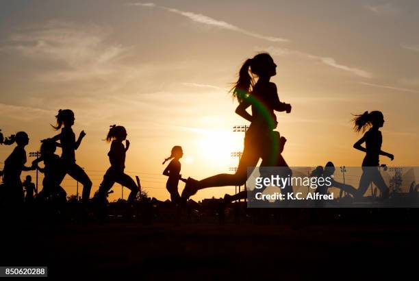 runners compete in a 5k at sunset in corona, california. - marathon stock-fotos und bilder