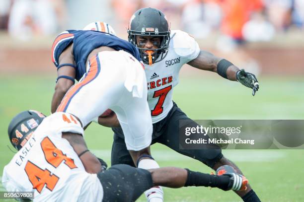 Wide receiver Noah Igbinoghene of the Auburn Tigers gets tackled by linebacker Travonte Easley of the Mercer Bears and defensive back Eric Jackson of...