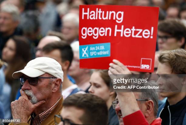 Supporter of Social Democrats Party leader and candidate for Chancellor Martin Schulz holds up a placard which reads "Stand firm against hatred"...