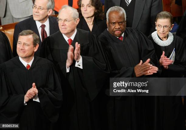 Supreme Court Chief Justice John Roberts joins Justice Anthony Kennedy, Justice Clarence Thomas, and Justice Ruth Bader Ginsburg in applauding the...