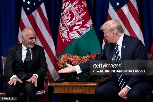 Afghanistan's President Ashraf Ghani and US President Donald Trump shake hands before a meeting at the Palace Hotel during the 72nd United Nations...