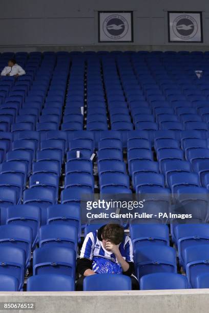 Dejected Brighton & Hove Albion fan sits alone in the stands