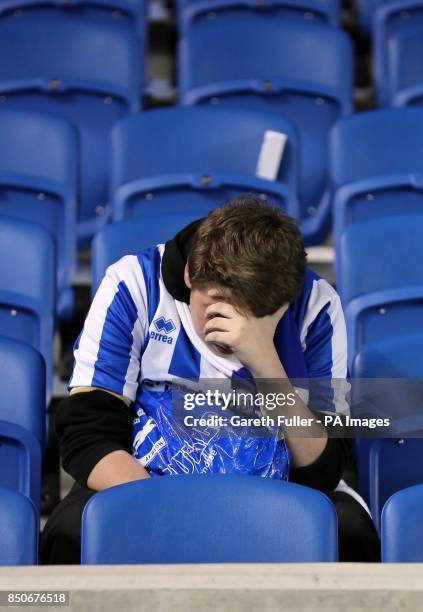 Dejected Brighton & Hove Albion fan sits alone in the stands