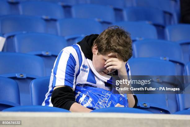 Dejected Brighton & Hove Albion fan sits alone in the stands