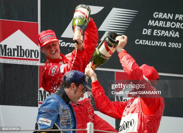 Michael Schumacher et Rubens Barrichello celèbrent leurs victoire en compagnie de Fernando Alonso au grand prix d'Espagne à Barcelone en mai 2003.