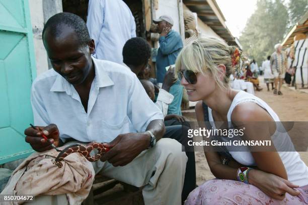 Heidi Klum regarde travailler un artisant sur un marché lors de ses vacances à Malindi au Kenya en décembre 2003.