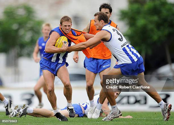 Daniel Harris of the Kangaroos is tackled by David Hale during a Kangaroos AFL training session at Arden Street Oval on February 25, 2009 in...