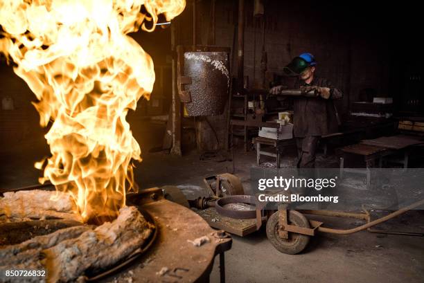 An employee prepares to load a crucible of molten aluminum onto a hoist at the Lite Metals Co. Foundry in Ravenna, Ohio, U.S., on Wednesday, Sept....