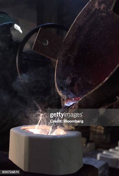 Molten magnesium is poured out of a crucible and into a mold at the Lite Metals Co. Foundry in Ravenna, Ohio, U.S., on Wednesday, Sept. 20, 2017. The...