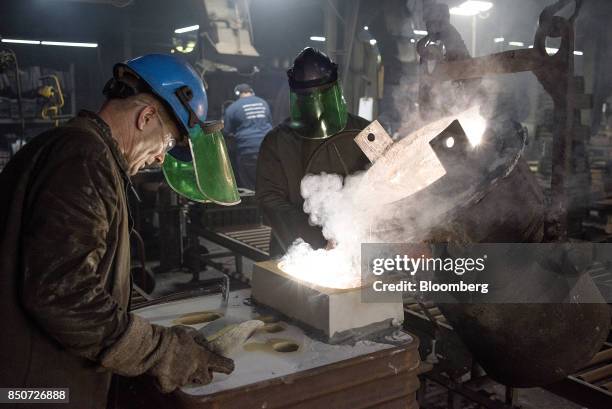 Employees pour molten magnesium out of a crucible and into a mold at the Lite Metals Co. Foundry in Ravenna, Ohio, U.S., on Wednesday, Sept. 20,...