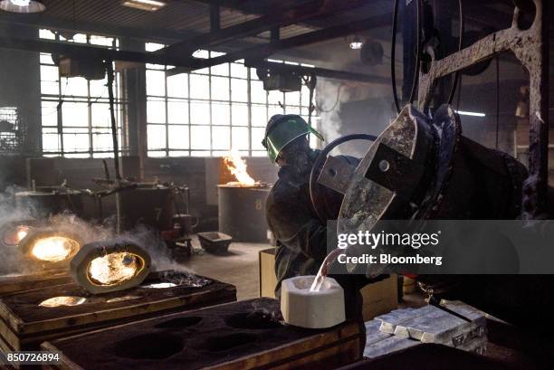 An employee pours molten magnesium out of a crucible and into molds at the Lite Metals Co. Foundry in Ravenna, Ohio, U.S., on Wednesday, Sept. 20,...