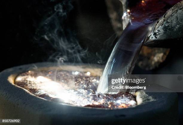 Molten magnesium is poured out of a crucible and into a mold at the Lite Metals Co. Foundry in Ravenna, Ohio, U.S., on Wednesday, Sept. 20, 2017. The...