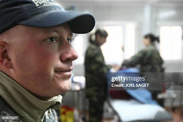 Doctor Mathew X stands next to an Afghan woman being treated by a French doctor of the 27th BCA on February 19, 2009 at the Morales-Frazier Forward...