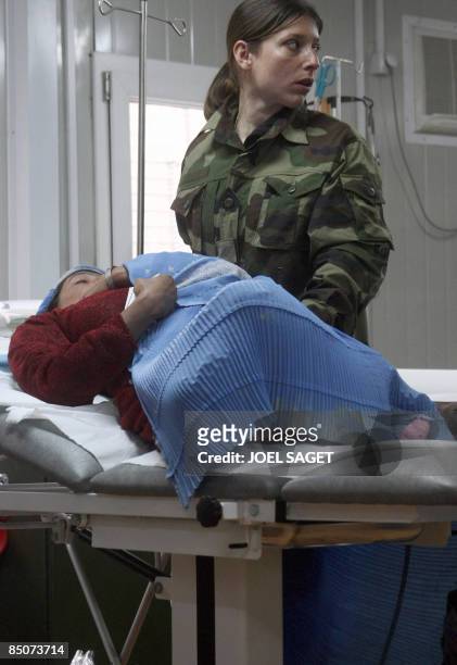 An Afghan woman is treated by a French doctor of the 27th BCA on February 19, 2009 at the Morales-Frazier Forward Operating Base in Nijrab, Kapisa...