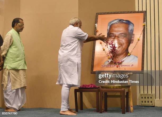 Prime Minister Narendra Modi pays floral tribute to the portrait of Laxman Rao Inamdar during his birth centenary celebration and Sahakar Sammelan,...