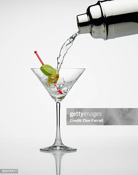 martini pour lime and olive - martini glass stockfoto's en -beelden