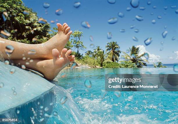 crossed child feet on an overflow over a pool - fregate stock pictures, royalty-free photos & images