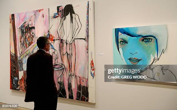 Man looks at two of the finalists for the prestigious Archibald Art Prize at the New South Wales Art Gallery in Sydney on February 25, 2009. The...