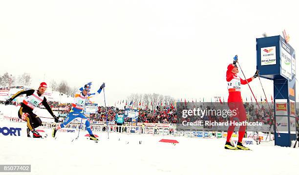 Ola Vigen Hattestad of Norway celebrates as crosses the finish line to win the Gold medal as Axel Teichmann of Germany and Ville Nousiainen of...