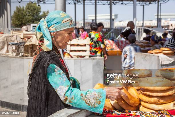Woman buying non bread, Siyob Market, also known as Siab Market, Samarkand, Uzbekistan.