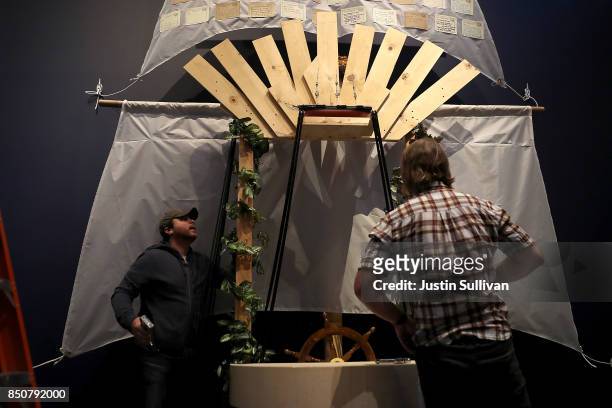 Artists Chris Treggiari and Peter Foucaulton work on their "Ghost Ship" art installation at the Oakland Museum of California on September 21, 2017 in...