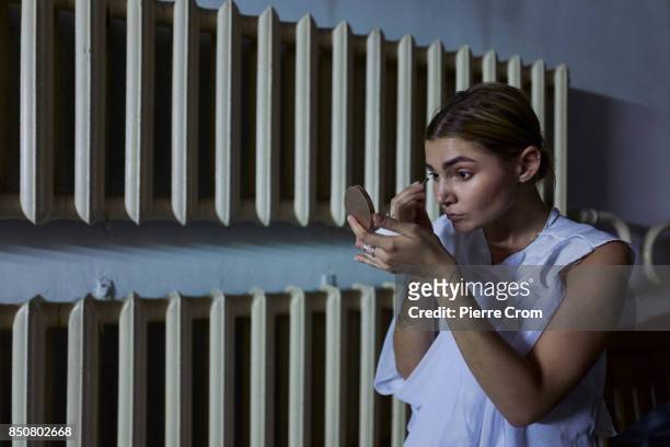 An artist adjust her make-up before a theater representation on September 21, 2017 in Minsk, Belarus. Young Theater artists from Bulgaria, Belarus,...