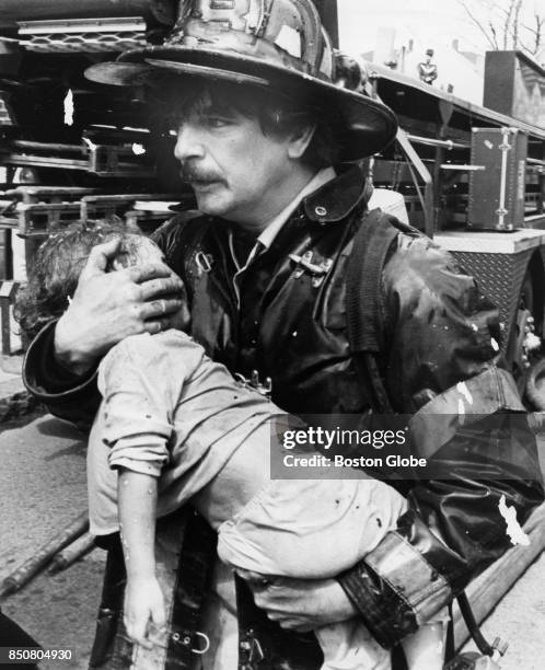 Boston Firefighter carries Janene Riley from the scene of a fire at Vinton Street in South Boston, April 17, 1978.