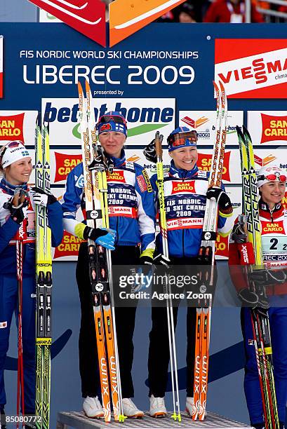 Winners Virpi Kuitunen and Aino-Kaisa Saarinen of Finland celebrate on the podium beside 2nd placed Sweden team member Anna Olsson and 3rd placed...