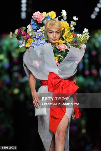 Model Gigi Hadid presents a creation for fashion house Moschino during the Women's Spring/Summer 2018 fashion shows in Milan, on September 21, 2017....