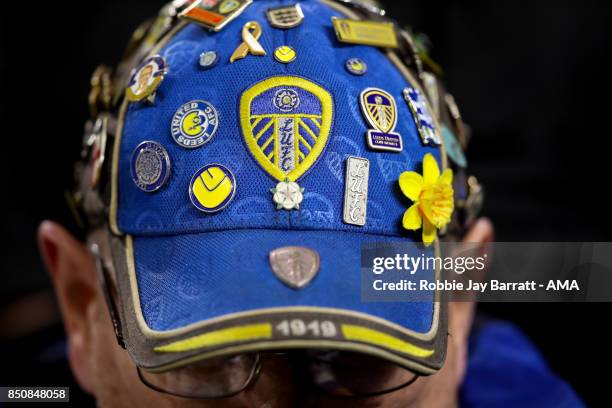 Fan of Leeds United wears a cap covered in pin badges during the Carabao Cup Third Round match between Burnley and Leeds United at Turf Moor on...