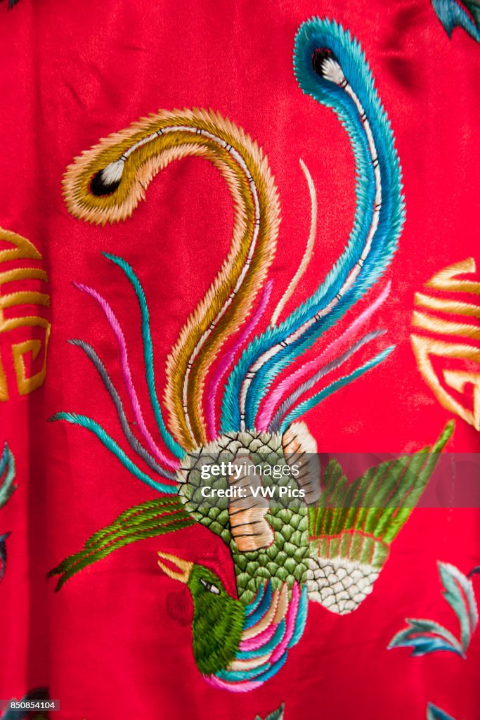 Colourful red Chinese embroidered silk garment depicting a phoenix bird