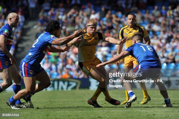 Castleford Tigers' Oliver Holmes is tackled by Wakefield Wildcats' Taulima Tautai and Kyle Trout during the Super League Magic Weekend at the Etihad...
