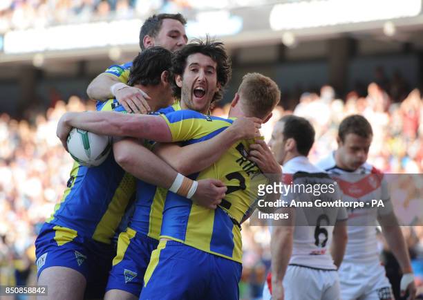 Warrington Wolves' Chris Riley celebrates with team-mates after scoring a try during the Super League Magic Weekend at the Etihad Stadium, Manchester.